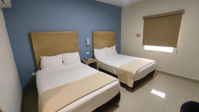 Habitación con dos camas y muro azul
